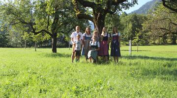 Familie Grünwald  © Familie Grünwald  Eine Familie steht vor einem Apfelbaum